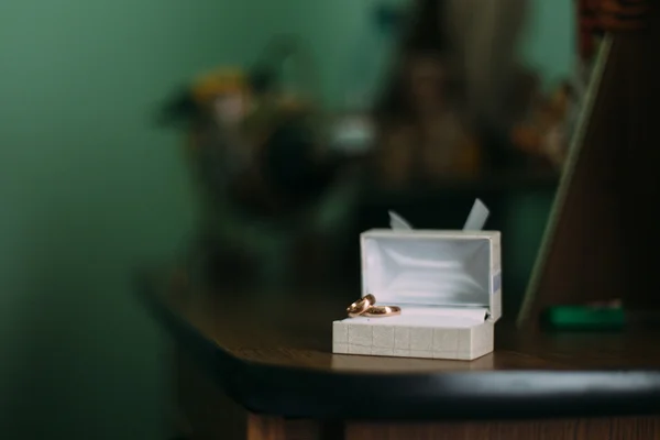 Luxo elegante anéis de casamento de ouro na caixa branca na mesa de madeira — Fotografia de Stock