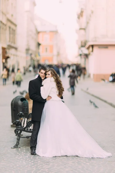 Beautiful married couple standing embracing in the old city with wonderful architecture — Stok fotoğraf