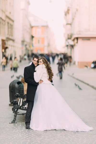 Beautiful married couple standing embracing in the old city with wonderful architecture — 스톡 사진