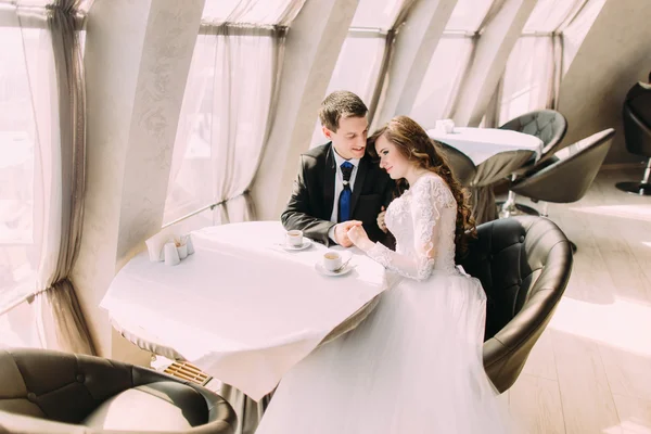 Cute young married couple hugging sitting in coffee shop — ストック写真