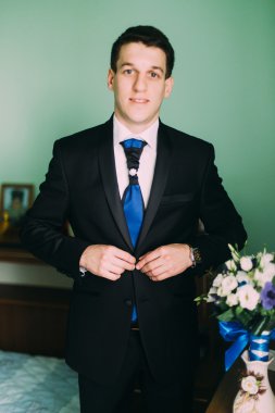 Pencerenin yanında duran zarif damat düğmeleri ceket