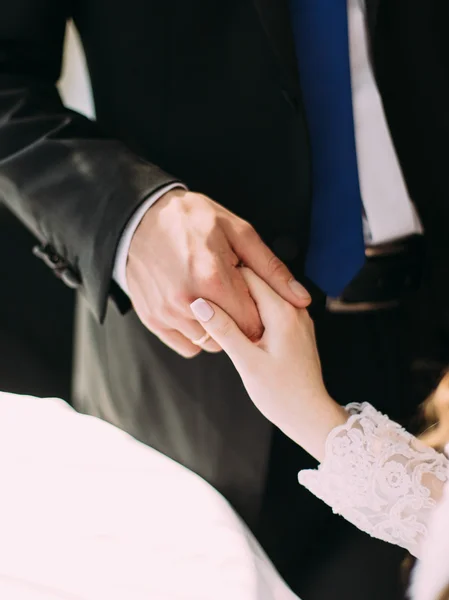 Linda novia y novio tomados de la mano con anillos de boda en — Foto de Stock