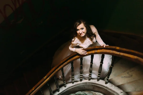 Noiva de luxo elegante em vestido branco posando em escadas de madeira velha, vista superior — Fotografia de Stock