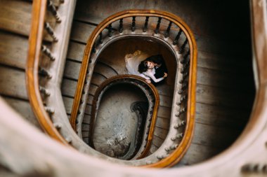 Yakışıklı damat güzel gelinler boyun eski ahşap merdiven üzerinde kapalı, öpüşme ana sayfa görünümü