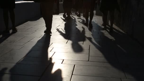 Shadows of people walking in city. Street procession. — Stock Video