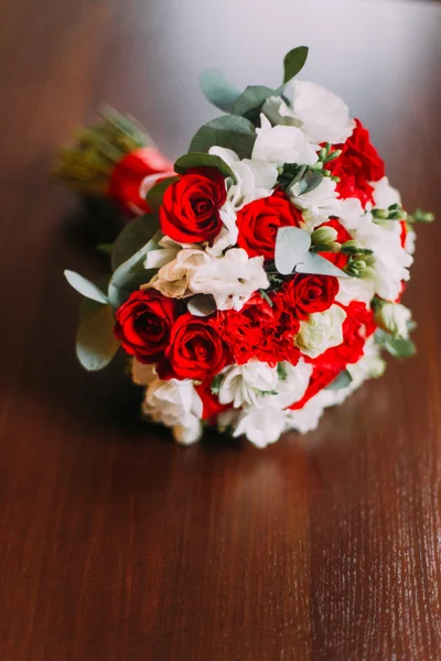 Buquê de casamento com rosas vermelhas e brancas em fundo rústico de madeira — Fotografia de Stock