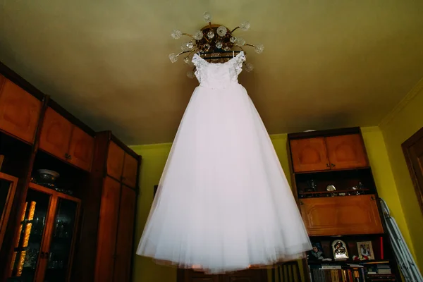 ホテルの部屋で光沢に掛かっている白いウェディング ドレス — ストック写真