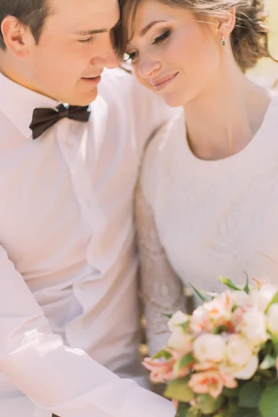 Boldog érzéki jóképű vőlegény és a szőke szép menyasszony, fehér ruhában átölelve, zár-megjelöl — Stock Fotó