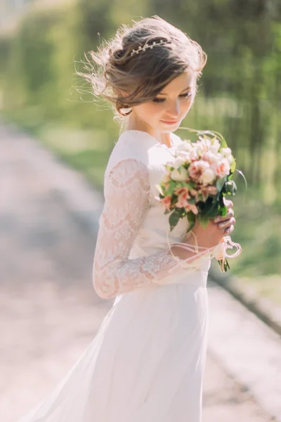 Hermosa novia rubia con ramo de flores de primavera al aire libre — Foto de Stock