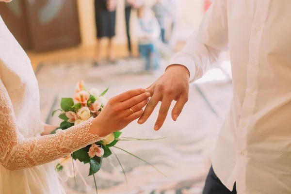 Mains du marié et de la mariée portant une bague sur le doigt, cérémonie de mariage au bureau du greffe, gros plan — Photo
