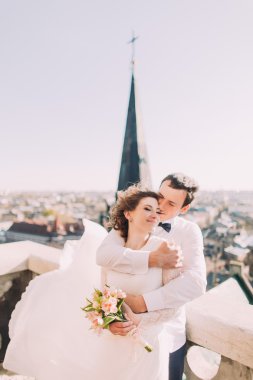 Eski şehir manzarası ile balkonda sarılma güzel düğün çift, yakın çekim