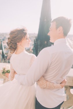 Güzel şehvetli sarışın gelin ve yakışıklı damat kale balkonda birbirlerine bakarak sarılma, yakın çekim
