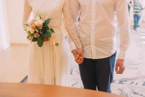 Mariée et marié se tenant les mains avec des bagues lors de la cérémonie de mariage — Photo