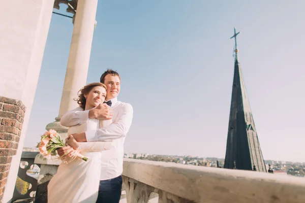 Güzel şehvetli sarışın gelin ve yakışıklı damat kale balkonda bakarak sarılma — Stok fotoğraf