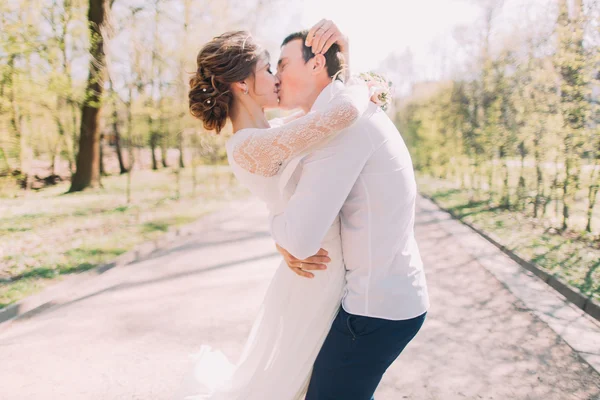 Romantisch sprookje getrouwd echtpaar in witte kleren zoenen in voorjaar park — Stockfoto