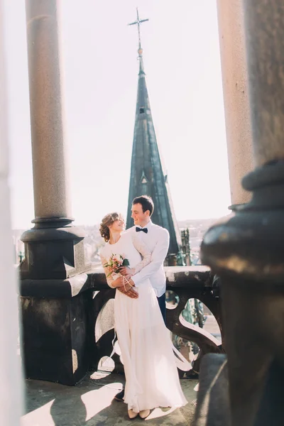 Piękny ślub para nowożeńców przytulanie na balkon z widokiem na Stare Miasto — Zdjęcie stockowe
