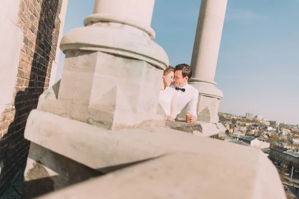 Όμορφη αισθησιακό ξανθιά νύφη και όμορφος groom αγκάλιασμα βλέπουν ο ένας τον άλλον στο μπαλκόνι του κάστρου, κάτω προβολή — Φωτογραφία Αρχείου