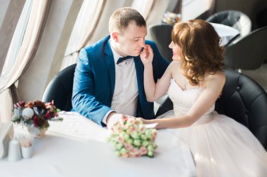 Yüz zarif damadın restoranda oturan mavi elbiseli dokunmadan muhteşem mutlu kahverengi saçlı gelin