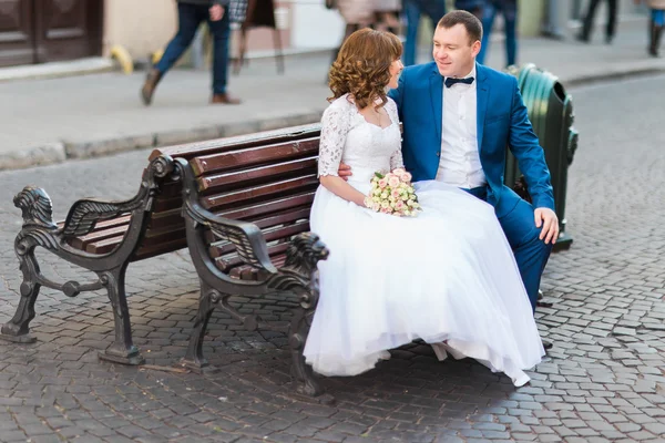 Elegantní nádherný šťastné nevěsty a ženicha, sedí na lavičce — Stock fotografie