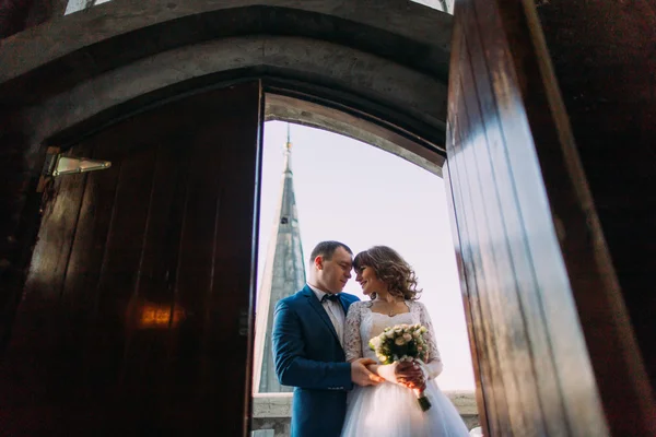 A háttérben a régi, fából készült ajtó átfogó érzéki esküvői pár — Stock Fotó