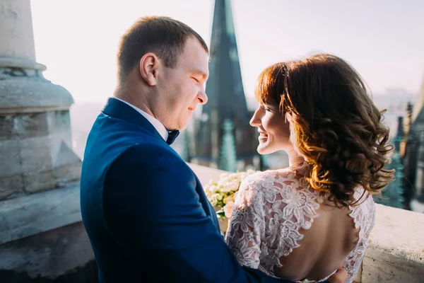 Szelíd, szép menyasszony és a vőlegény tartja kezében a csokor néztek egymásra, az ősi erkélyen, közelkép — Stock Fotó