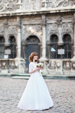 Genç gülümseyen gelin gül kokulu, cityscape arka planda doğru seyir