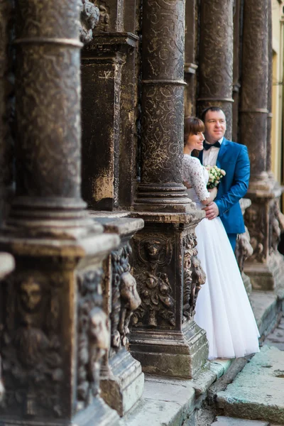 Novia romántica sensual recién casada y novio abrazándose delante de un viejo edificio con columnas — Foto de Stock