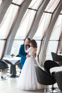 Güzel gelin ve nişanlısı boş Restoran windows tarafından sarılma içinde