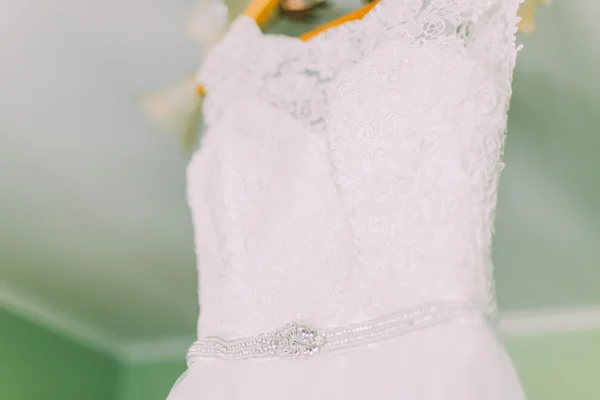 Vista de cerca del vestido de novia colgando en la habitación de hotel —  Fotos de Stock