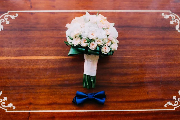 Accesorios de boda: pajarita de novio y hermoso ramo de novia sobre un fondo rústico de madera —  Fotos de Stock