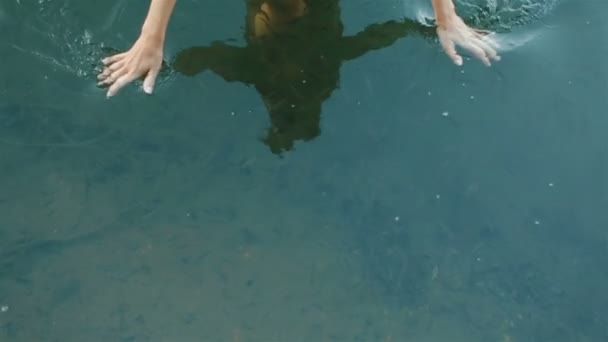 Reflection of beautiful fragile hands of fantasy young girl nymph in the cleah water with little healing fishes. Fish spa for skin care close up — Wideo stockowe