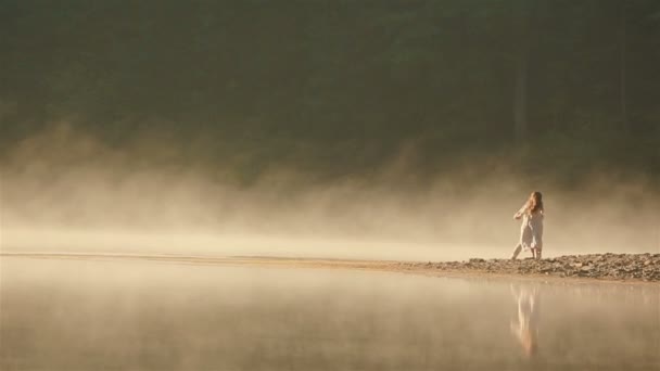 カルパチアの美しい山の湖で黄金の霧の中で夕日に踊るウクライナの民族衣装の幸せな田舎のカップル。人間と自然の永遠の調和 — ストック動画