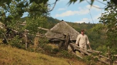 Geleneksel Ukraynalı baltalı genç oduncu çıplak ayakla ormana gider.