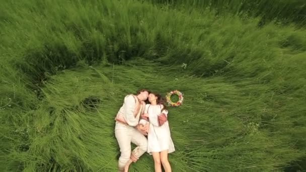 Hermosa pareja enamorada en ropa tradicional ucraniana abrazándose en el campo verde. Vista superior — Vídeos de Stock