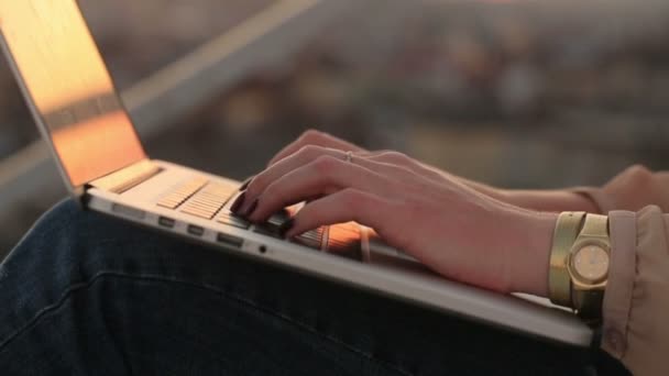 Primer plano de la joven mujer de negocios que utiliza el ordenador portátil al aire libre. Mujer manos con manicura mecanografía de cerca con fondo de paisaje urbano — Vídeos de Stock