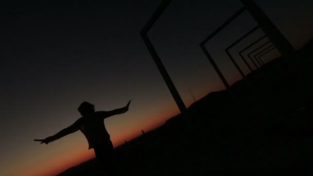 Silhouette de jeune femme heureuse dansant sur le pont high-tech moderne au coucher du soleil — Video