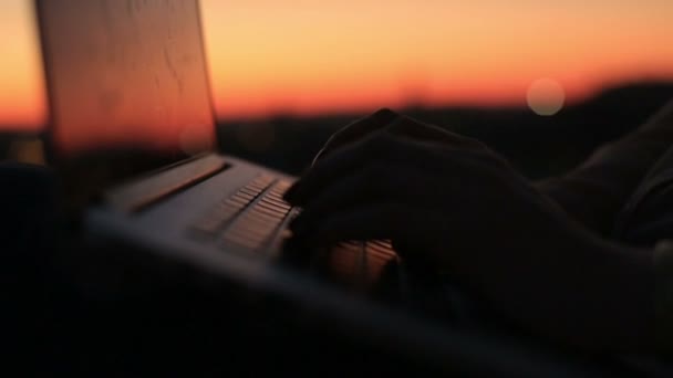 Nahaufnahme von Frauenhänden, die bei Sonnenuntergang auf der Laptop-Tastatur tippen — Stockvideo