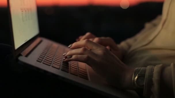 关闭女人手上日落在笔记本电脑键盘上打字。在工作过程中的年轻商界女强人 — 图库视频影像