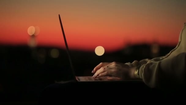 Primer plano de las manos de las mujeres con la escritura de manicura roja en el teclado de las computadoras portátiles en la puesta del sol. Mujer joven charlando en Facebook en un fondo borroso — Vídeos de Stock