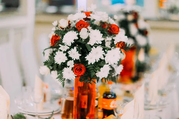 Nahaufnahme eines Straußes roter und weißer Blumen, die auf dem Hochzeitstisch stehen — Stockfoto