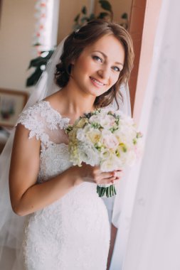 pencerenin yakınındaki çiçekli beyaz elbiseli genç güzel rüya gelin