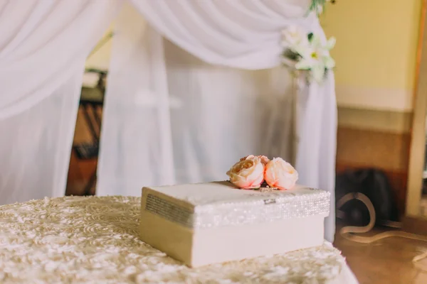 Ramo de rosas frescas de color naranja con gran caja de regalo blanco en la mesa — Foto de Stock