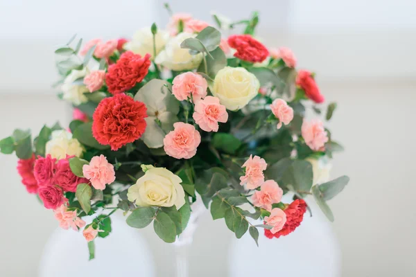 Bouquet d'été de roses colorées dans un vase moderne sur fond de mur blanc abstrait — Photo