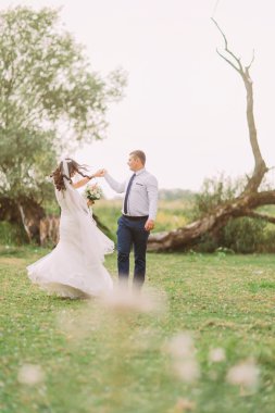 Zarif damat güzel ağaçlar Park arka plan üzerinde dans ile mutlu şık gelin