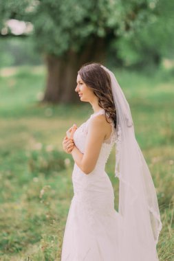 Göğsünü yeşil park üzerinde onu tutan peçe giyen güzel genç gelin eller