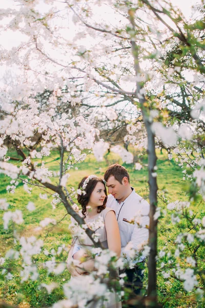 Amor y ternura. Hermosa pareja amorosa joven abrazándose en el jardín de primavera en flor. citas románticas — Foto de Stock