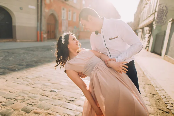 Beautiful bridal couple dancing at sunset on the streets of old city — Stock Photo, Image