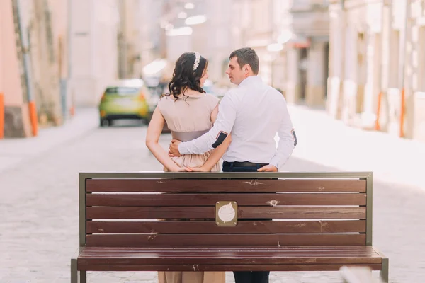 Romantický pár pózuje na lavičku na ulici staré město — Stock fotografie