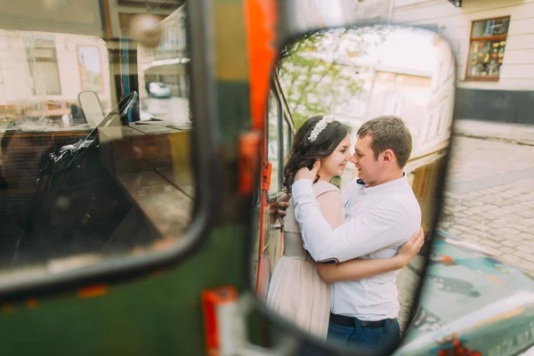 Reflektion av ganska ung kvinna klädd i blommig pannband och stilig man i backspegeln — Stockfoto