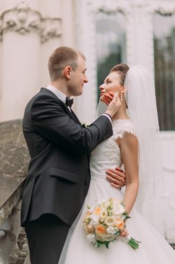 Siyah elbiseli yakışıklı damat usulca gelinler yüz dokunur